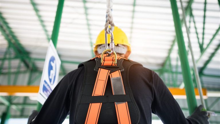 Worker tied off with a safety harness and line at height