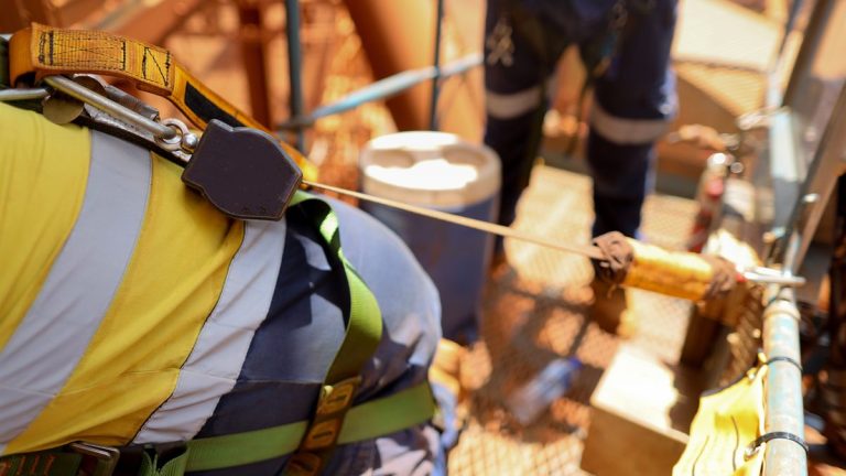 Operator on an elevating work platform clipped to the anchorage with a fall arrest harness