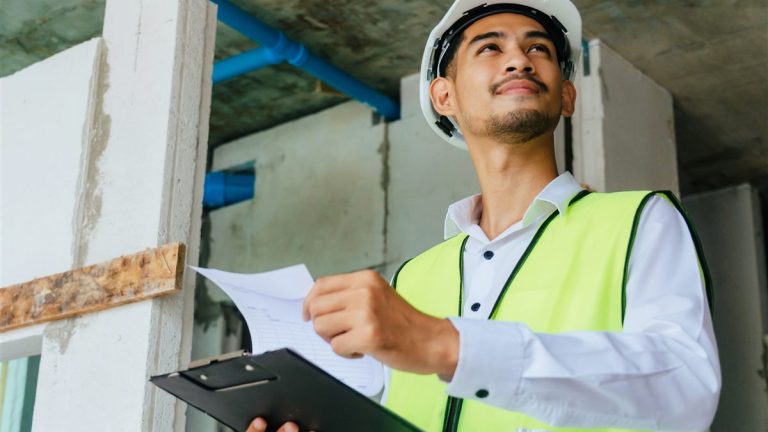 Foreman inspecting a construction site with a clipboard